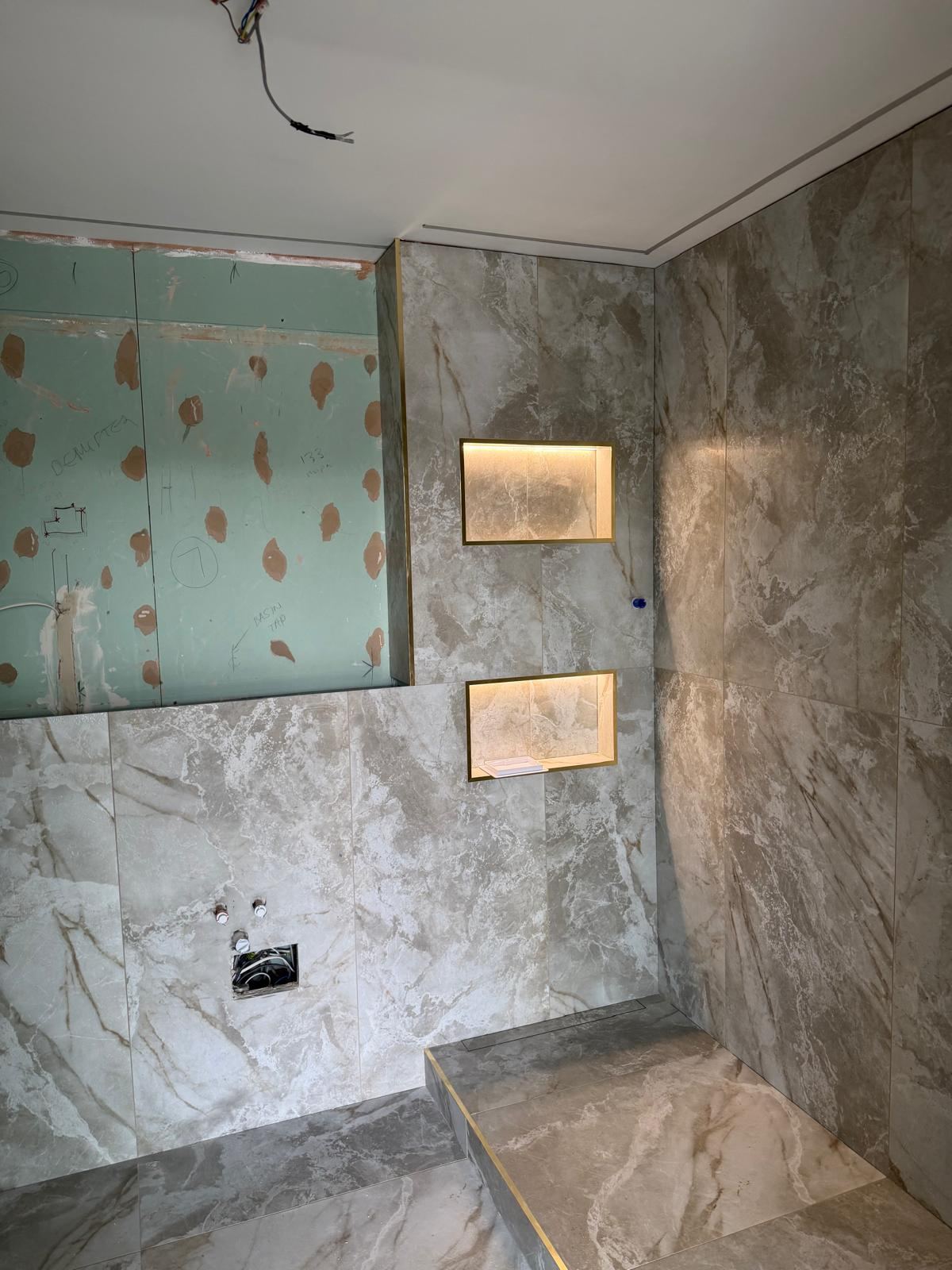 Tiled shower area with two illuminated LED niches and recessed ceiling lighting