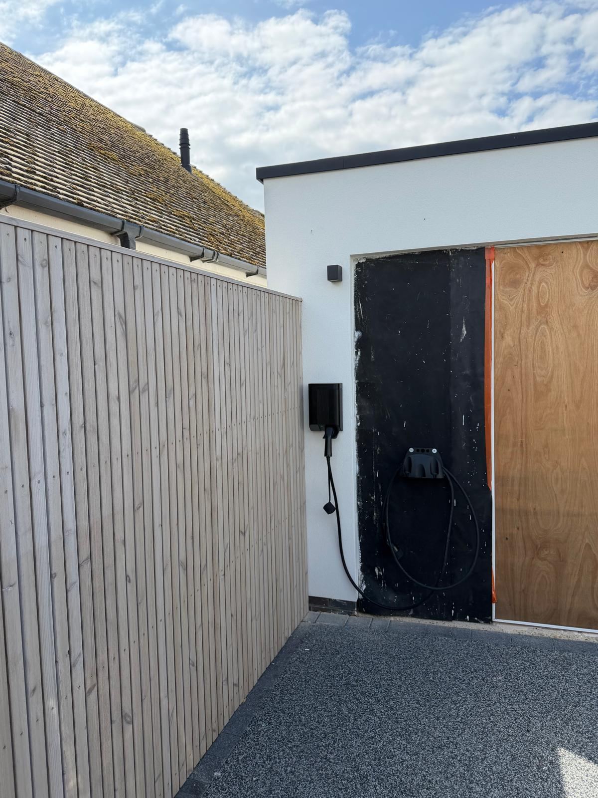 EV charger installation in progress in Rochester, backing onto timber cladding