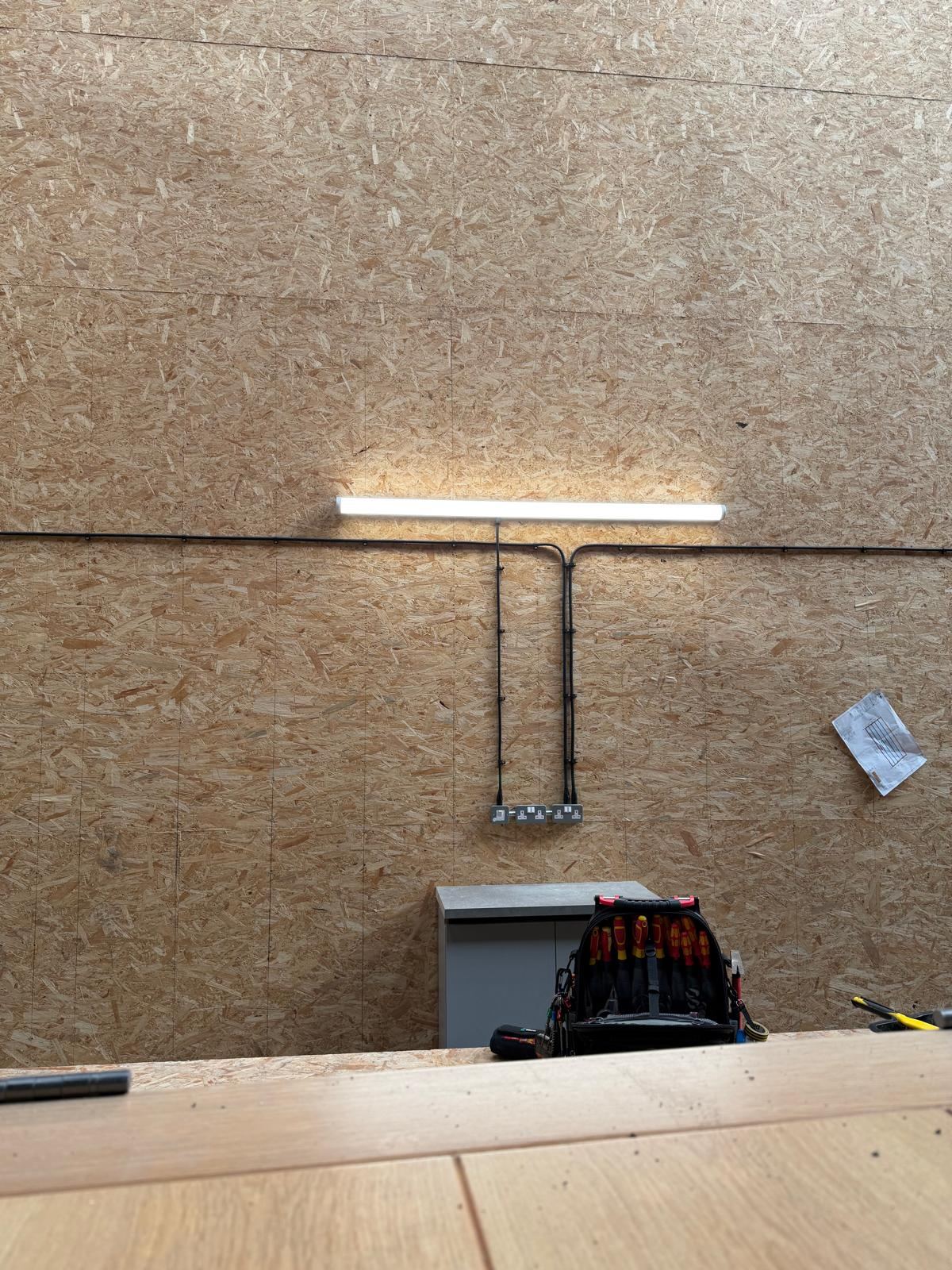 LED bench light fitted with surface-mounted power outlets below
