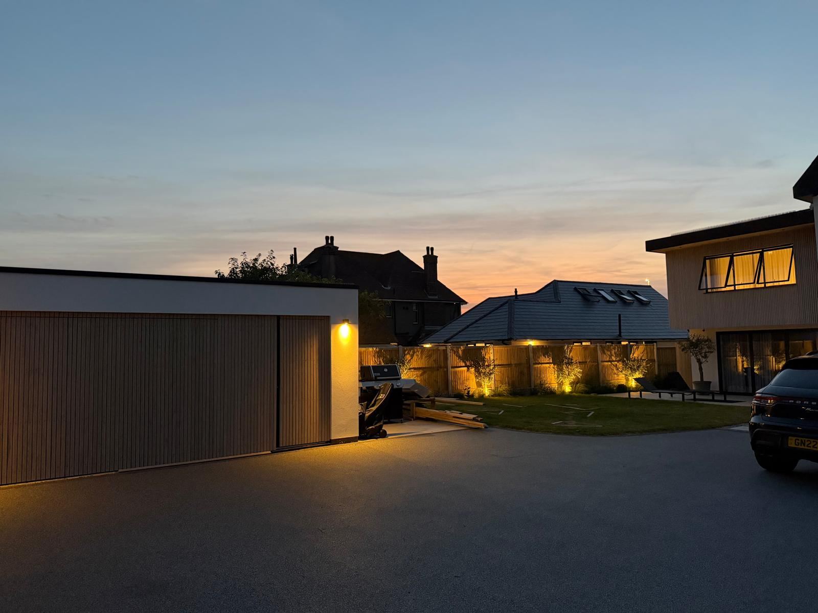 Garden and driveway lighting installation at dusk after the new-build electrical package