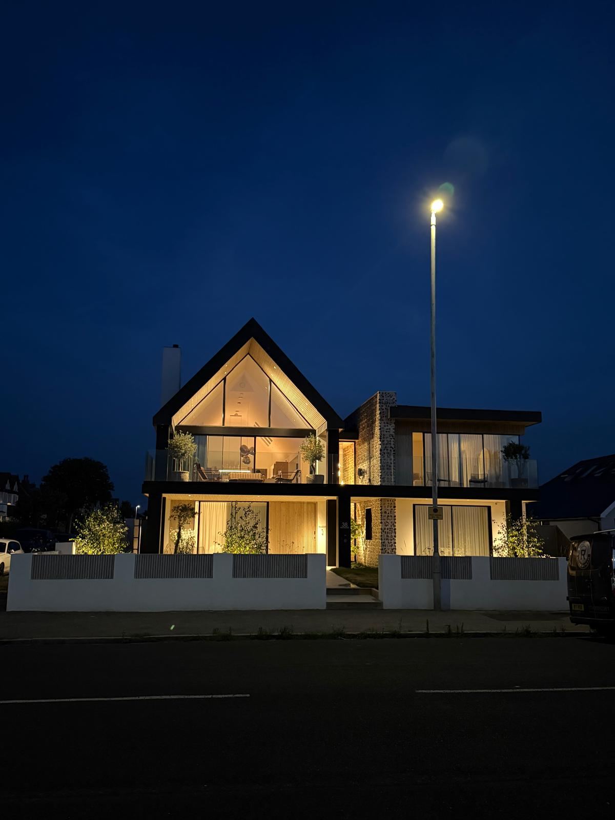 Westbrook seafront new-build property lit up at sunset, showing the full electrical design and build installation